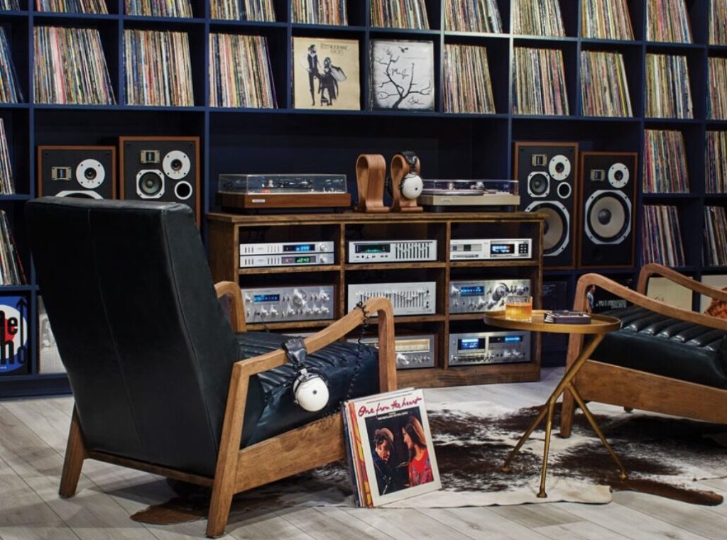 Two chairs in front of a wall of records and a nice stereo.